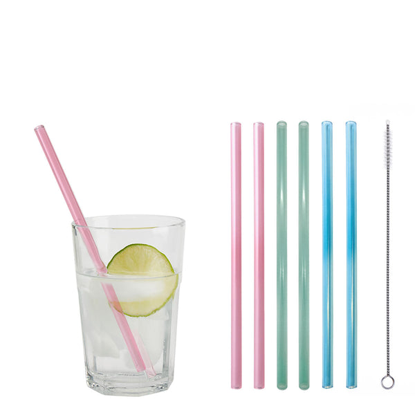Ein Trinkglas mit einer Scheibe Limette und einem Glastrinkhalm in Mattrosa. Daneben sind 6 farblich sortierte Glastrinkhalme (20 cm, gerade; 2 x Mattrosa, 2 x Mint, 2 x Hellblau) und eine Reinigungsbürste aus Nylon