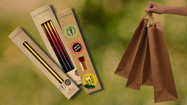 Verpackungen für den Einzelhandel: 3 Verpackungsvarianten von Glastrinkhalme und rechts eine Hand mit Einkaufstüten aus Papier